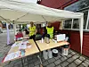 To damer i sanitetsforeningens refleksvester, på en stand.