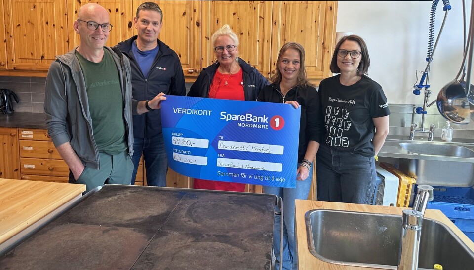 SpareBank 1 Nordmøre med stor gave til grendalaget folk foran komfyr med stort gavekort fra sparebank 1 nordmøre