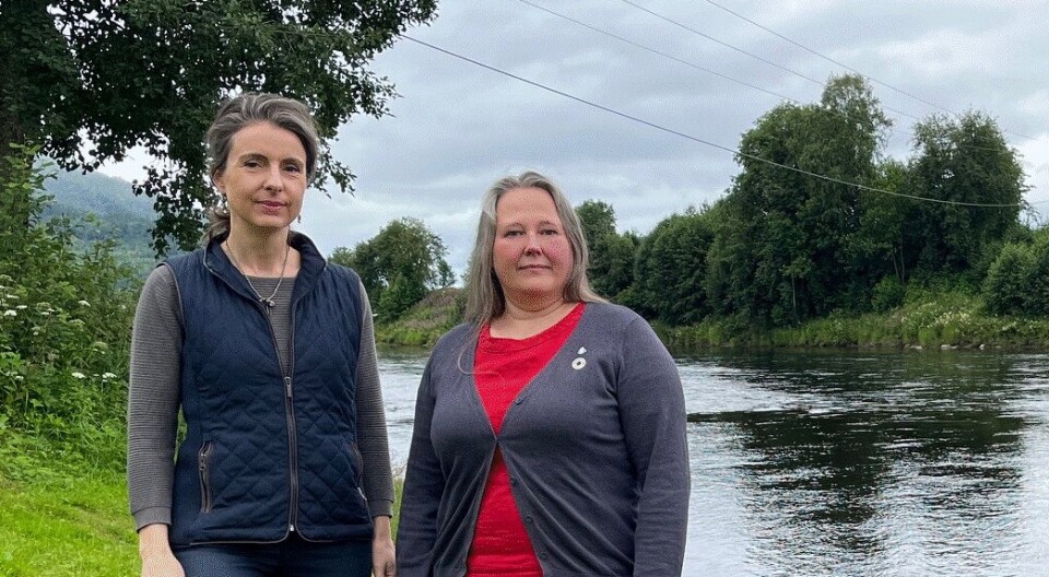 Jenny Klinge og Annett Ranes ber om en kompensasjonsordning for de som taper mye på at elva blir stengt for resten av sesongen. To damer som står på en elvebredd.