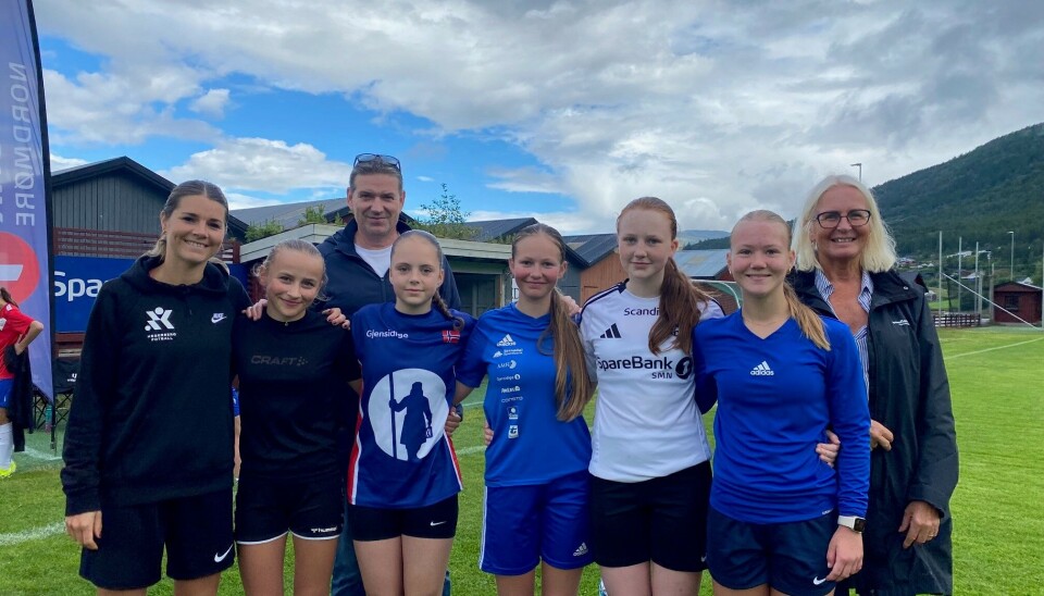 Arne og Liv fra banken bak, Andrine, Ildri, Idun, Ada, Solvor og Anna fra Surnadal IL foran. barn og voksne poserer på fotballbane