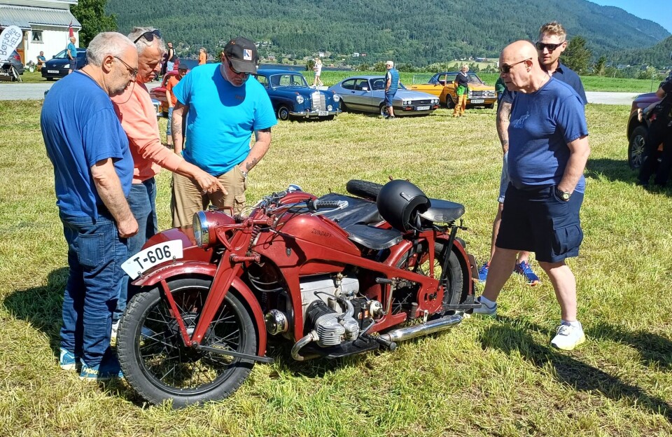 Eldre utgave av en Zundapp. En veteranmotorsykkel og veteranbiler utstilt på et jorde.