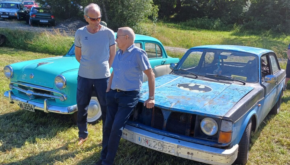 Volvo 242 fra 1977. To menn med to veteranbiler utstilt på et jorde.