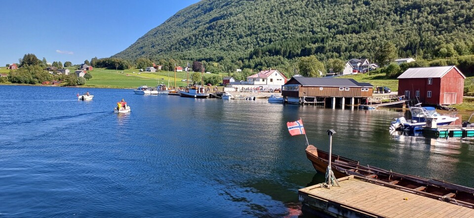 Fra Bøsaga mot butikken. Noen trebygninger ved fjorden.
