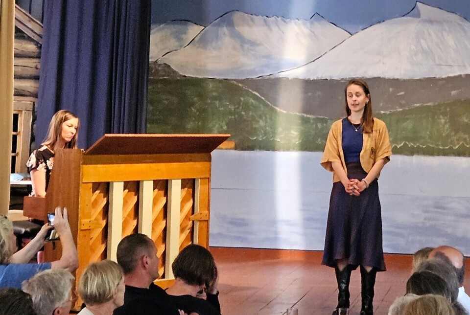 Mira leia oss støtt og humoristisk gjennom eit program med høg kunstnarisk kvalitet. Ei dame som står på en scene og snakker, og ei som sitter bak pianoet.
