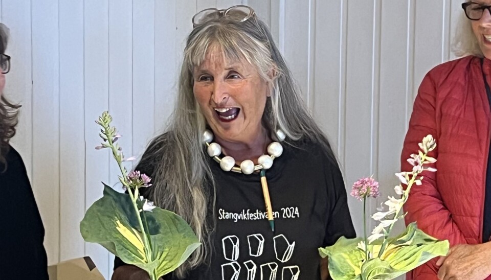 Brit Dyrnes delte ut blomar til festivalkunstnarane. dame med to blomsterbuketter