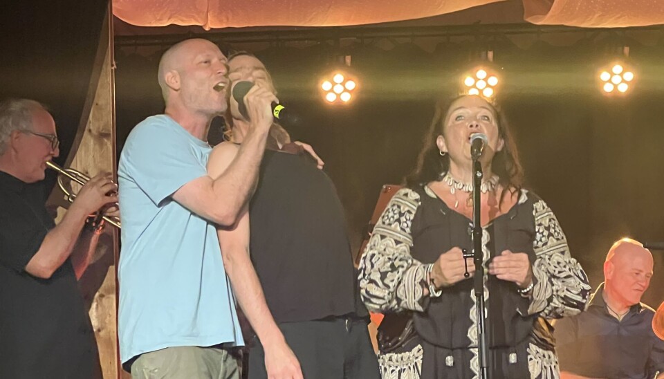 Feststemning med Enok Monk og Balkan Brasserie på scena. folk synger i mikrofon på scene