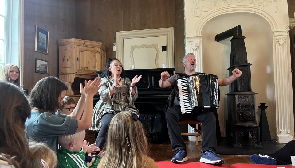 Anne og Jovan fikk med barna på klapping og synging. dame og mann med trekkspill klapper foran publikum