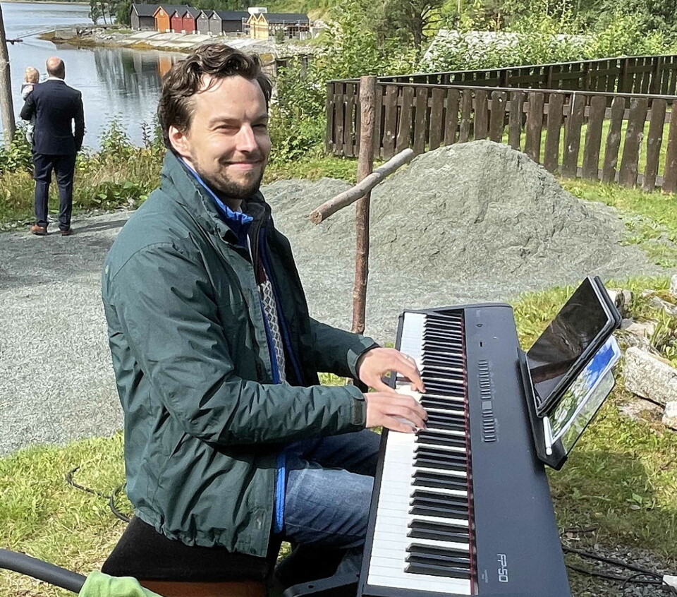 Vikarorganist Erik Rosenius varmar opp til salmespel og solosong. En mann som sitter og spiller på et elektronisk orgel utendørs.