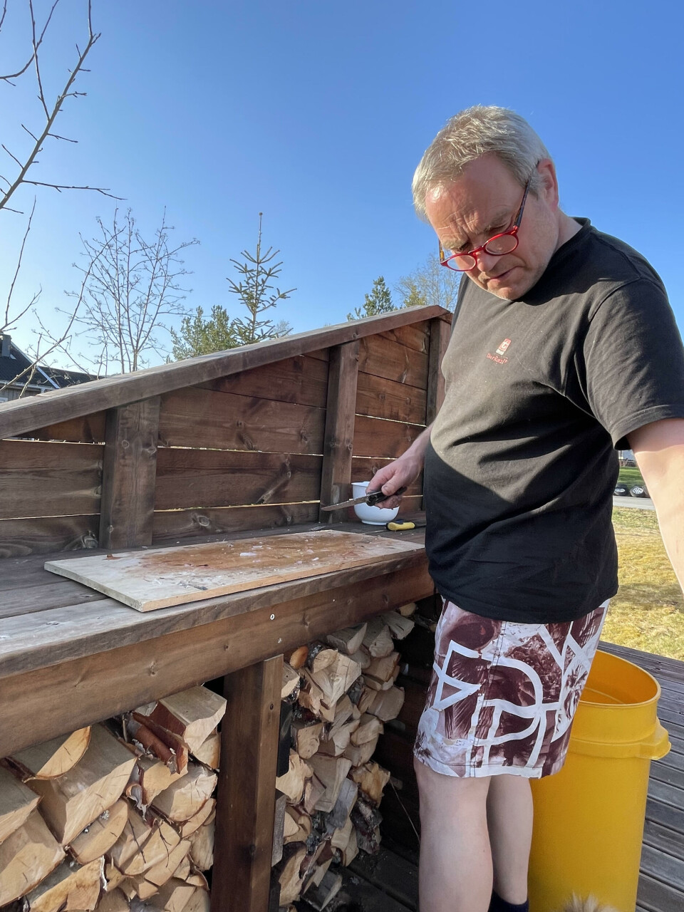 En mann står foran en benk