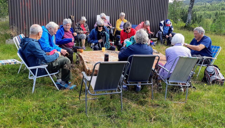 Matrast på stølen til Alvstusetra Menn og kvinner sitter på hagestoler og spiser
