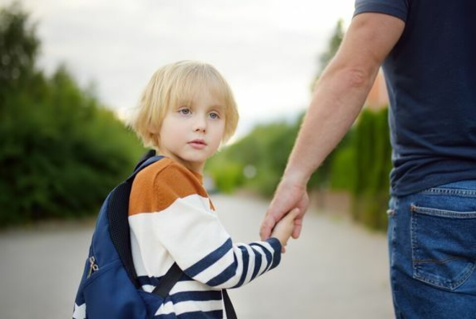 For mange starter skolen allerede ved SFO i god tid før den tradisjonelle skolestarten. En ung gutt holder hånden til en voksen