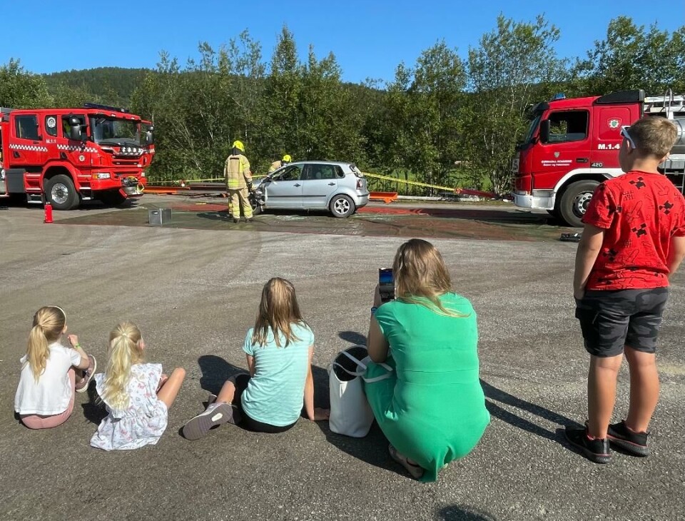 Brannvesenet vekket interesse blant store og små. Fem ser på menn og biler.