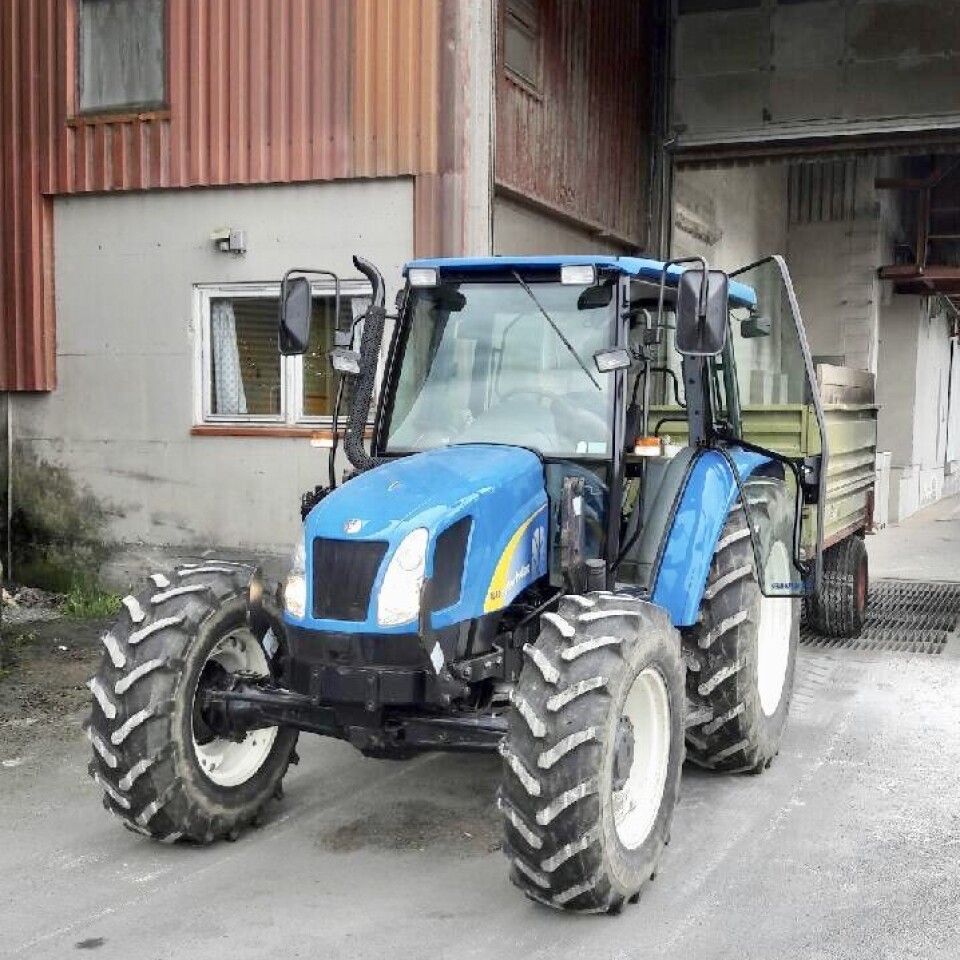 Arne Fiske tømmer lass på vegne av Ivar Fiske, også tidlig ute i år. Blå traktor med henger ved mølla.