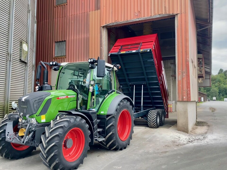 Røv Mølle i Surnadal tar i mot korn fra Surnadal og omland. Her ser vi Lars Johan Berset innom med et av årets første lass. Grønn traktor tømmer en stor rød henger hos Røv Mølle.