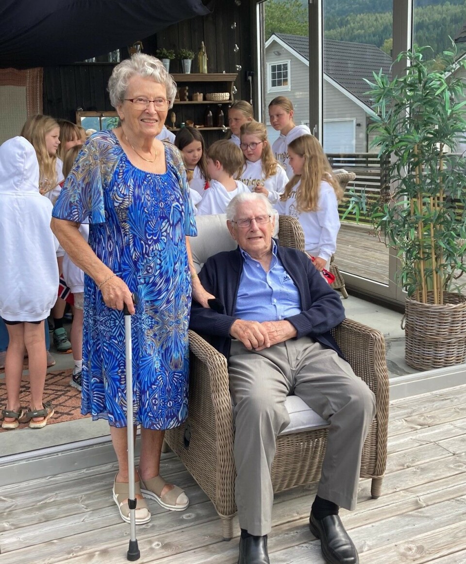 Jubilant Asbjørn sammen med sin kjære Ragnhild. En mann sitter i en stol og en kvinne står ved siden av ham og holder han i armen