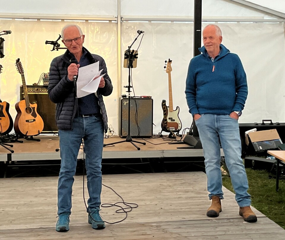 Odd Erling Dalsegg fortalte underholdende om oppveksten på Trøknaholt. To menn på en scene. Den ene med mikrofon.