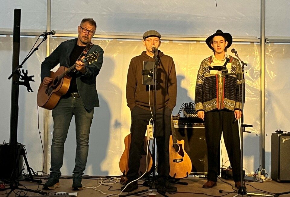 Karstein Mauset (med gitar), Hans Magne Brønstad og Sander Jonli Simonset (med munnspill) fikk stor applaus for sine musikalske innslag. Tre menn som står og spiller og synger på en scene.