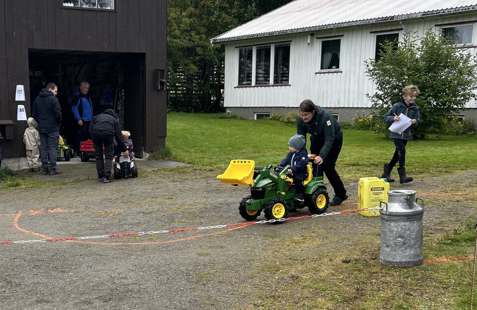 her kan man ta trø-traktorlappen. barn på trøtraktor blir skubbet av en voksen på en bane