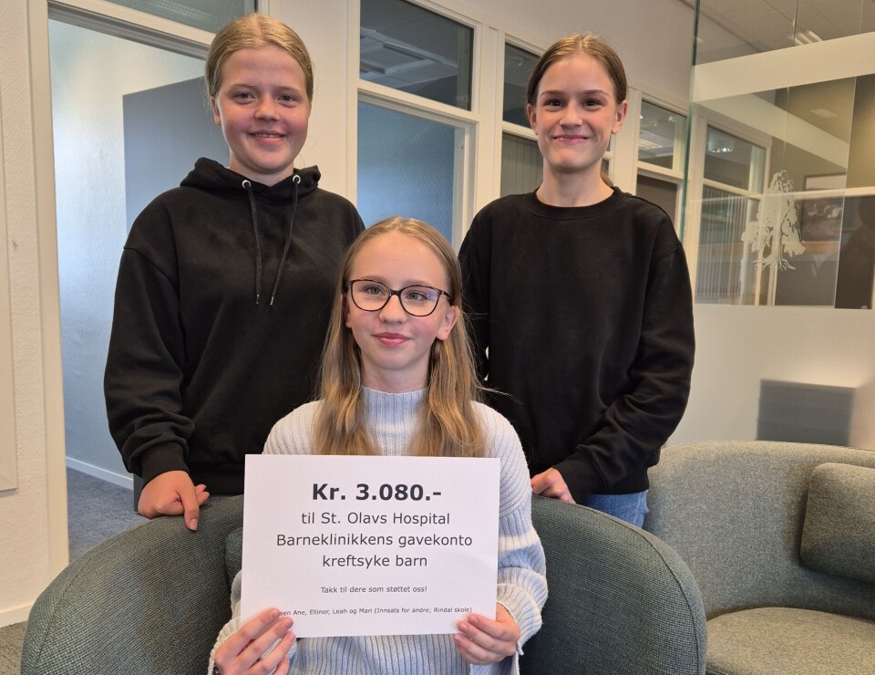 Leah, Mari og Ane satte inn penger på gavekontoen til Barneklinikken ved St. Olavs hospital Tre unge jenter med en plakat foran seg.
