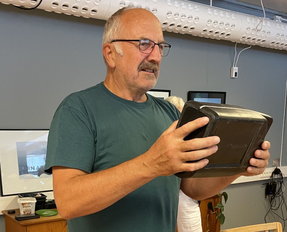 Lars Gudmund Røen med eiga oppfinning som skal lette trekkjinga. Bør takst patent på! En mann som står og holder ei bok.
