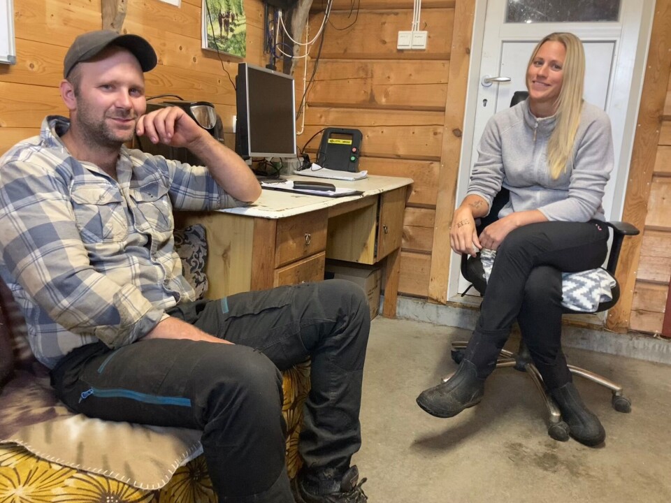 Paret er driftige og har bygget opp det meste av gården siden 2018. De takker besteforeldrene for all god hjelp på gården og med barna. Mann og dame på et kontor i fjøset med tømmervegger.