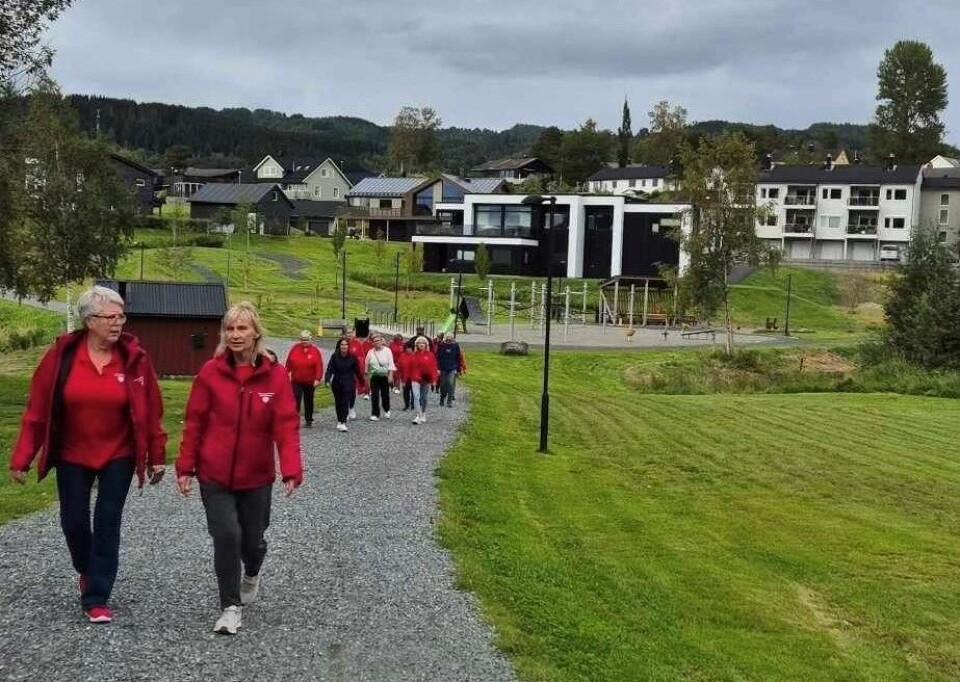 Inspirasjonssamling på Thon hotell Flere personer, de fleste i røde jakker, ute og går tur på en grusvei.