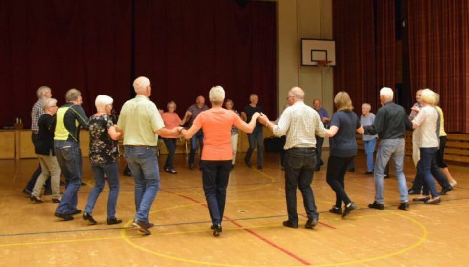 Surnadal folkedanslag. Mange mennesker som danser ringdans.