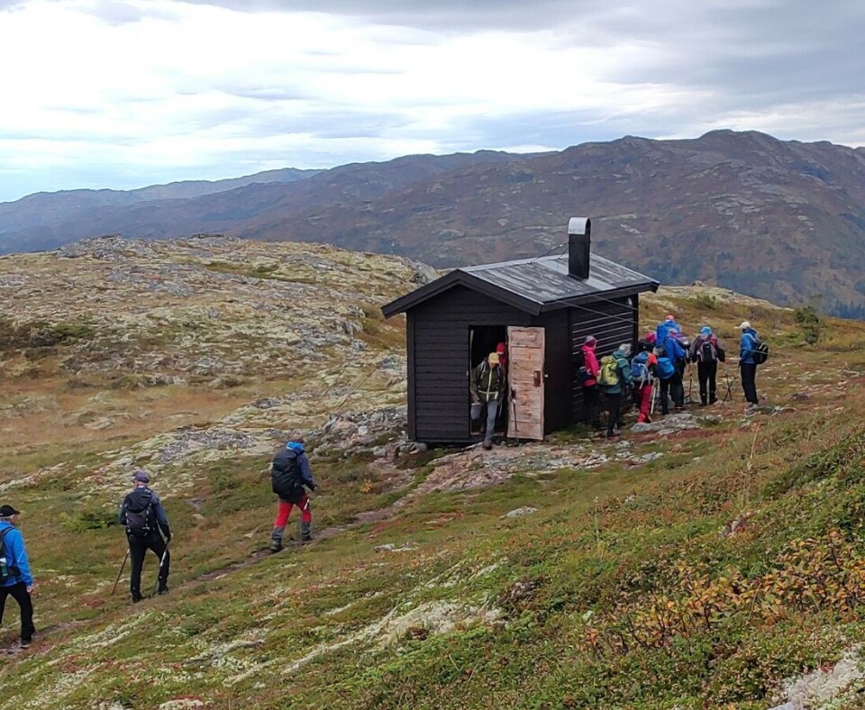 Tirsdagstur til Gimshøgda Turkledde folk inne i og utefor ei lita hytte på fjellet.