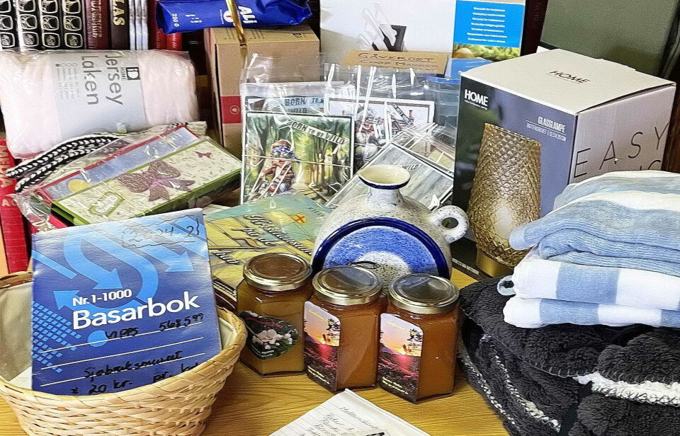 Litt av gevinstbordet til søndagens trekning. Et bord med gevinster til utlodning, og ei basarbok.