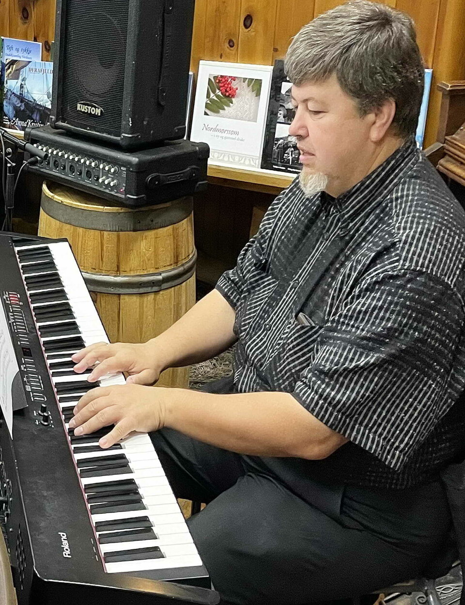 Alex Kurbanov trivst med å laga taffelmusikk på Bøfjorden Sjøbruksmuseum. Em mann som sitter og spiller piano.