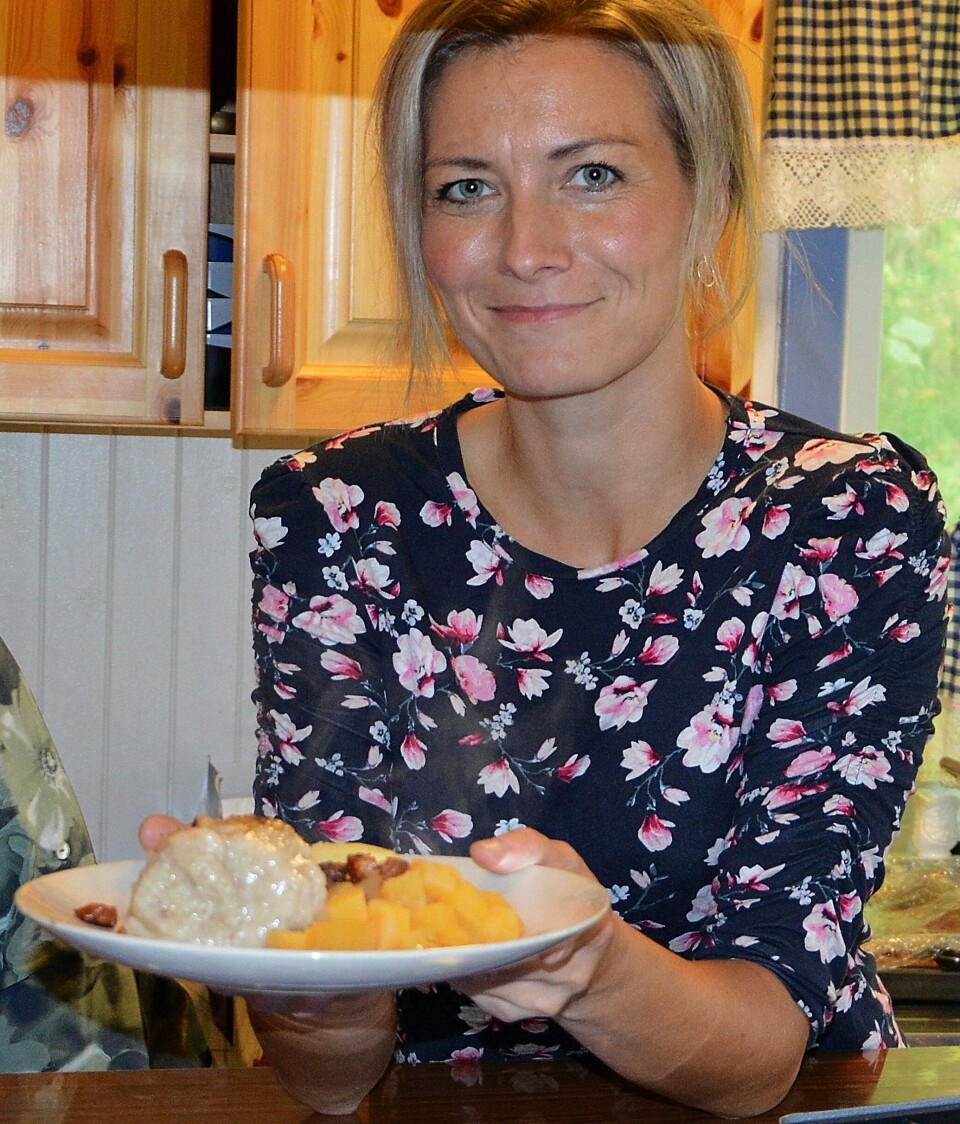 Gunnhild Vetleseter Bøe i historielaget gled seg til å servere sildball. Ei dame som holder fram en tallerken med sildball.