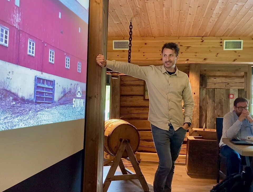 Tore Svinvik viser frem og forteller om deres prosess fra gammelt melkefjøs til topp moderne gourmet-restaurant i den lille grenda. Mann som kikker på en powerpoint med et rødt gammelt fjøs.