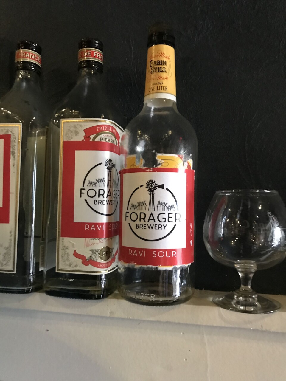 Tomme ølflasker og ett glass