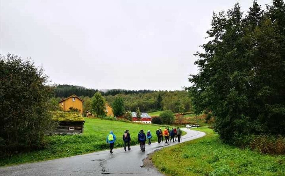 Det lysna opp når vi var attende til Åsen. Turgåere i regntøy på en asfaltert veg.