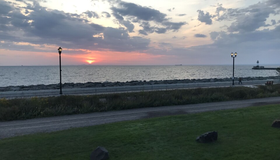 Soloppgangen siste morgen i Duluth sett fra hotellrommet. Soloppgang over en stor innsjø.