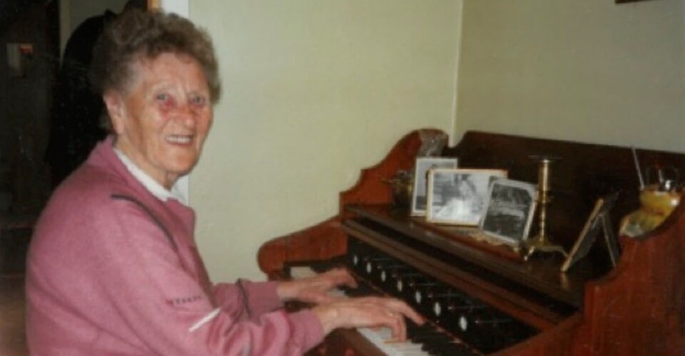 Ingeborg Almås. Ei eldre dame som spiller på et gammeldags orgel.