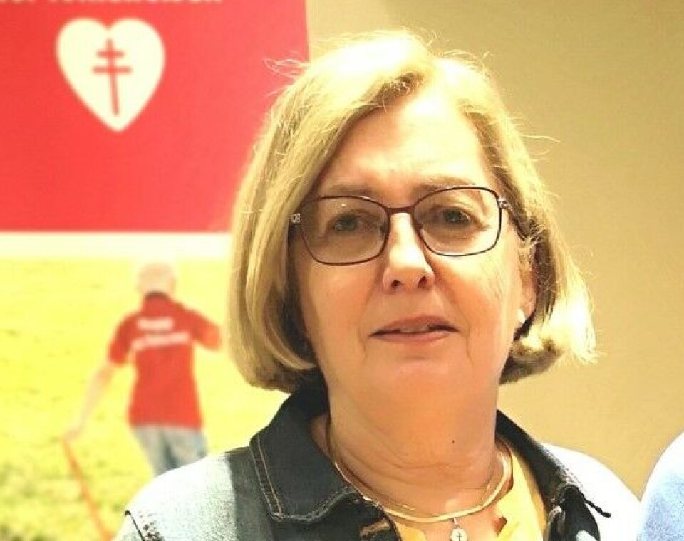 Ingunn Øye. Dame i dongerijakke foran plakat