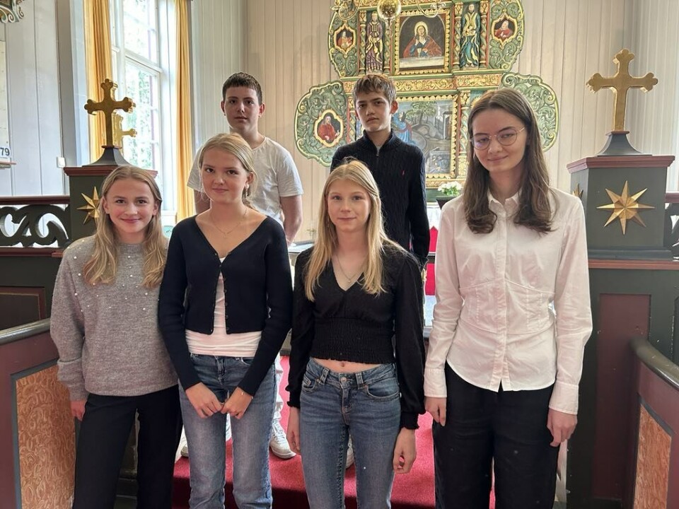 Årets konfirmanter i Mo. F.v: Ildri Fugelsøy, Emma Holten Fjærli, Maja Lervik Fiske og Ingunn Olea Harang Berset. Bak f.v: Kristoffer Hansen Røv og Jesper Rodal Fire jenter i fremste rekke, to gutter i bakerste rekke fremme i en gammel kirke.