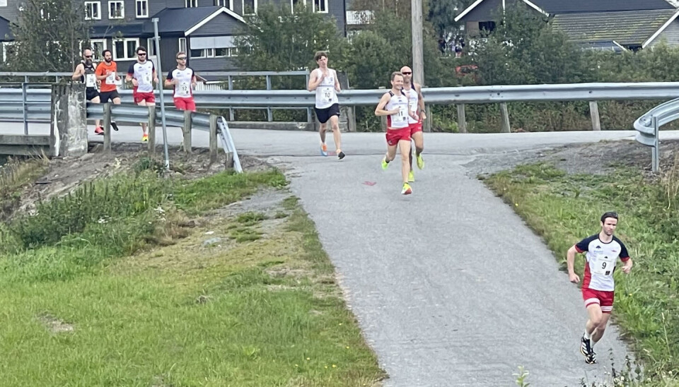 Etter få meter har de raskeste fått en luke Flere løpere løper over en bru og ned en bakke. I bakgrunnen et stort gått hus