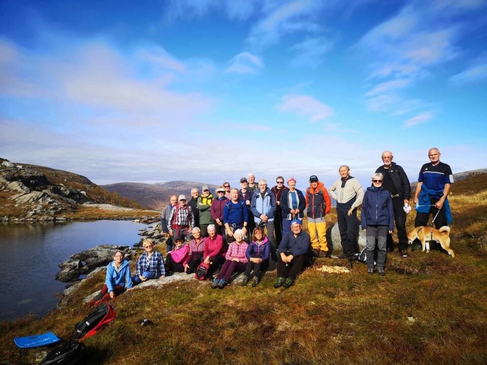 Fjellgruppetur til Vassdalen Ei gruppe turgåere oppstilt for fotografering ved et fjellvann.
