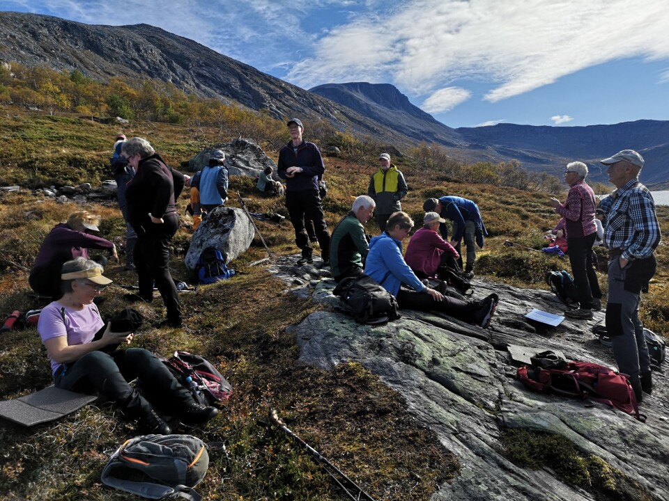 Kaffe og niste ved Vassdalsvatnet. Ei gruppe turgåere i fjellet som har tatt seg en matpause.