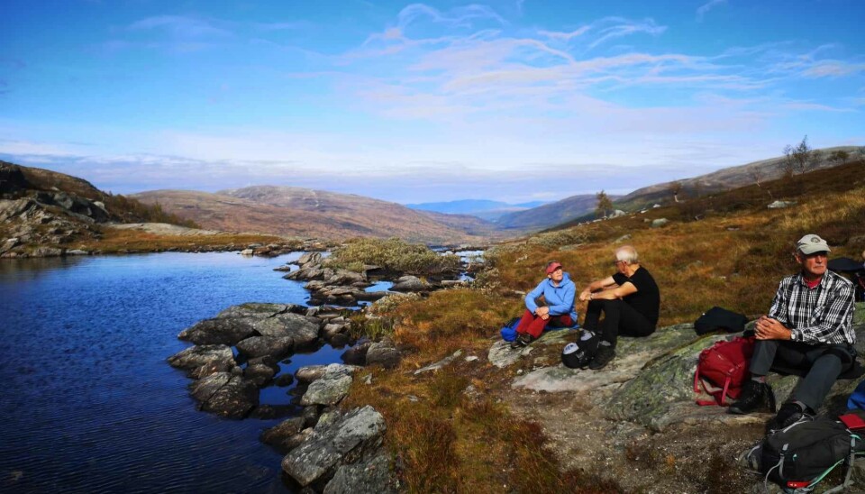 Fjellgruppetur til Vassdalen Noen turgåere som sitter og hviler ved et fjellvann.