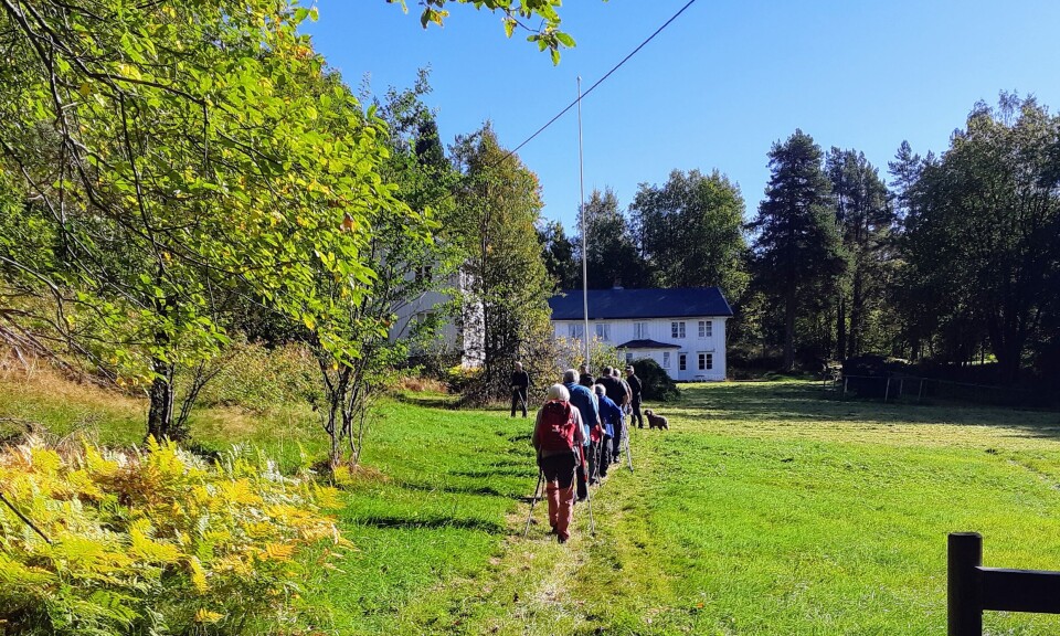 Stavgang til Årnestrøa Folk går på en sti over gresset mot et hvitt hus