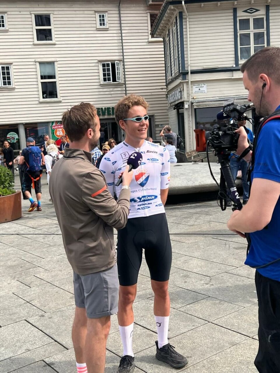 En ungdom som blir intervjuet av en mann med en mikrofon mens en annen mann står med et kamera.