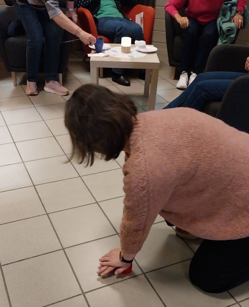 Hanne demonstreres hjertekompresjon på er hjerte som saniteten bruker å øve på. En kvinne viser på et gulv hvordan man gjør hjertekompresjoner