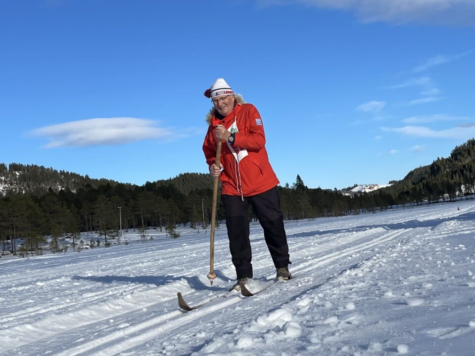 Arkivfoto fra treskirennet under årets festival Mann med rød anorakk med gamle ski og staver