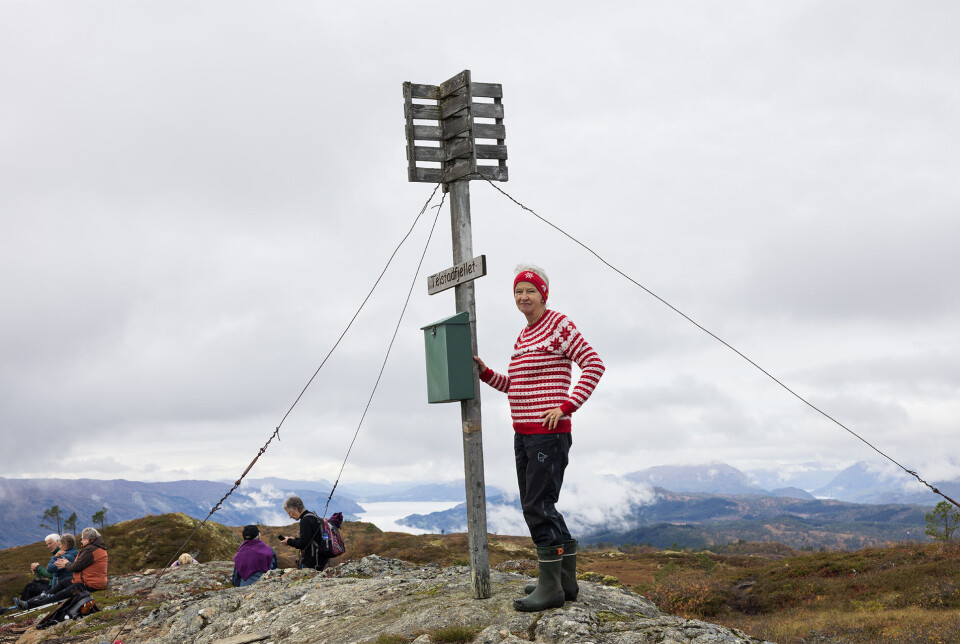 Ved Telstadfjellets topp, 580 moh. Ei dame som står ved en trimboks på en fjelltopp.