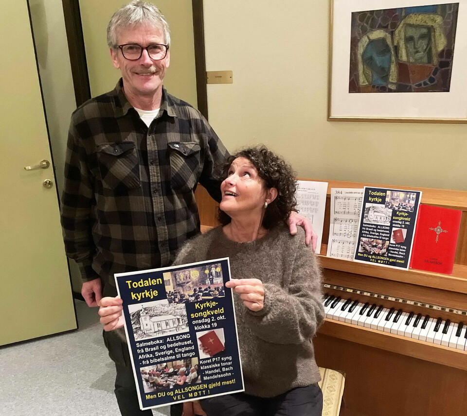 Med denne plakaten og med salmeboka som kjelde håpar koristane Kristian Settem og Borghild Talgø at mange blir med som publikum og medaktørar på allsongkvelden i kyrkja. mann og dame med plakat foran piano