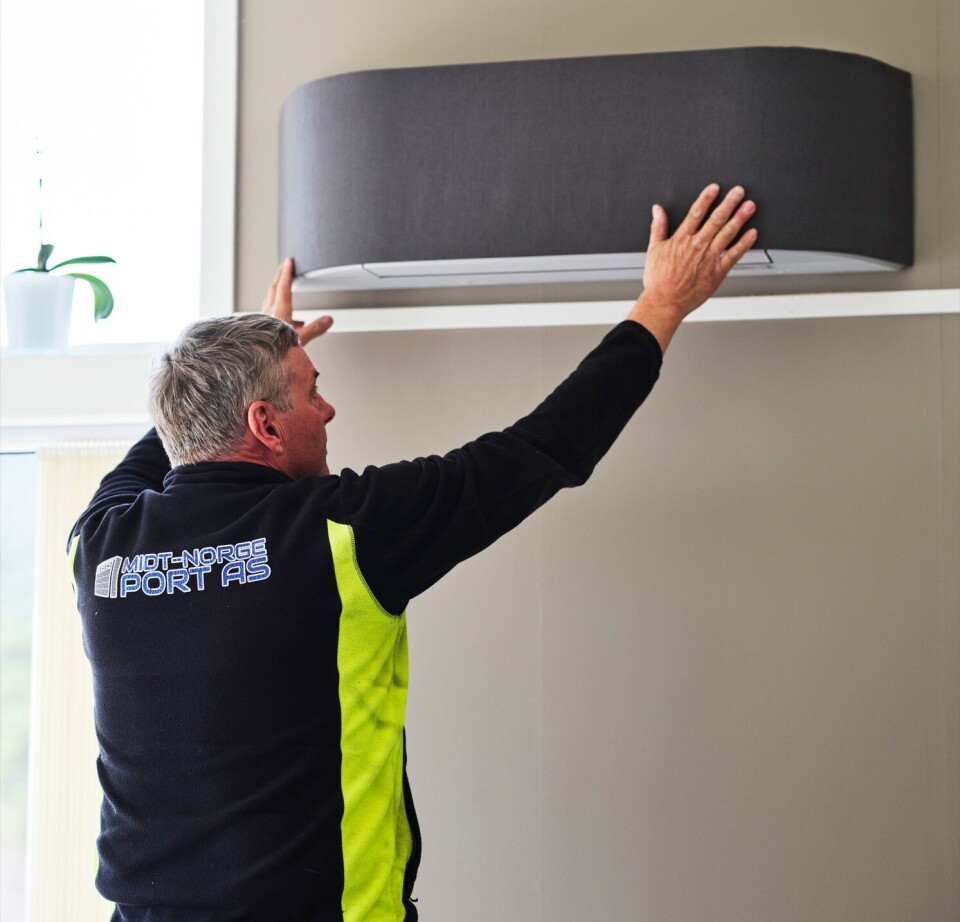 MidtNorge Port satser på varmepumper En mann i arbeidsklær som monterer ei varmepumpe.