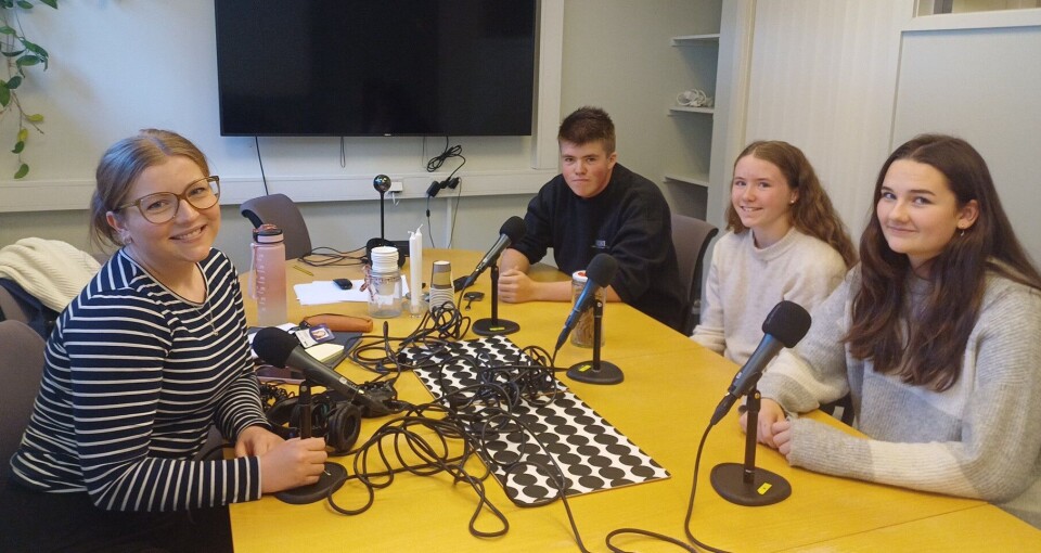 Kaspian, Ingrid og Mari sammen med programlederen fra NRK Trøndelag. Tre ungdommer og ei dame rundt et bord ed lydutstyr.